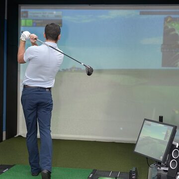 Man practicing golf on indoor simulator